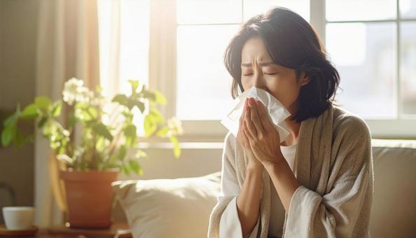 ティッシュで鼻をかむ日本人の若い女性 ティッシュで鼻をかむ日本人の若い女性の写真