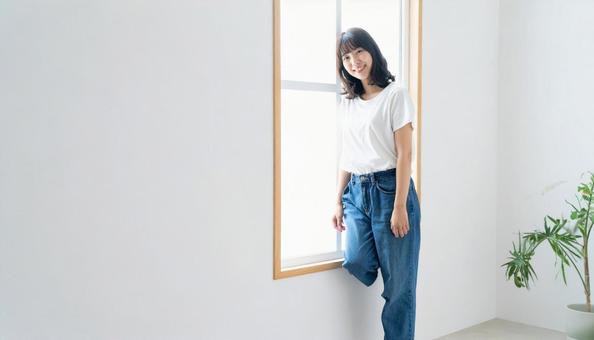 窓際に立つ女性 窓際に立つ女性の写真