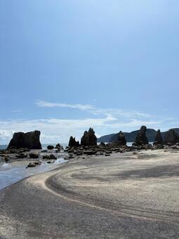 弧を描く砂浜と遠く続く橋杭岩 和歌山,串本,橋杭岩の写真素材