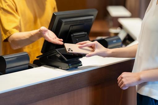 ショッピングをしてモバイル決済をする女性 モバイル決済,ショッピング,買い物の写真素材