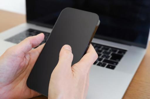スマートフォンとパソコンを使う手元 スマートフォン,ノートパソコン,pcの写真素材