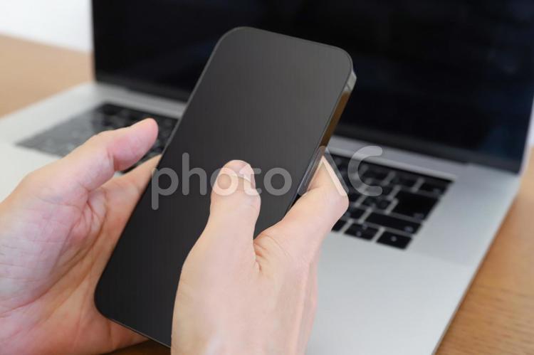 スマートフォンとパソコンを使う手元 スマートフォン,ノートパソコン,pcの写真素材