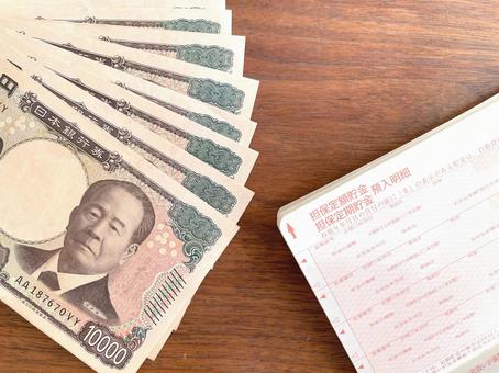 机上の通帳と紙幣のアップ お金,貯金,通帳の写真素材