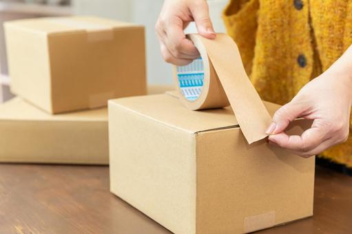 段ボールを梱包する手元 段ボール,ガムテープ,留めるの写真素材