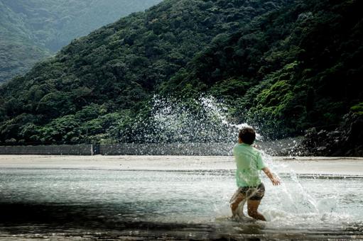 <素材>夕暮れの海で水遊びをする男の子 <素材>夕暮れの海で水遊びをする男の子 子供,海,海水浴の写真素材