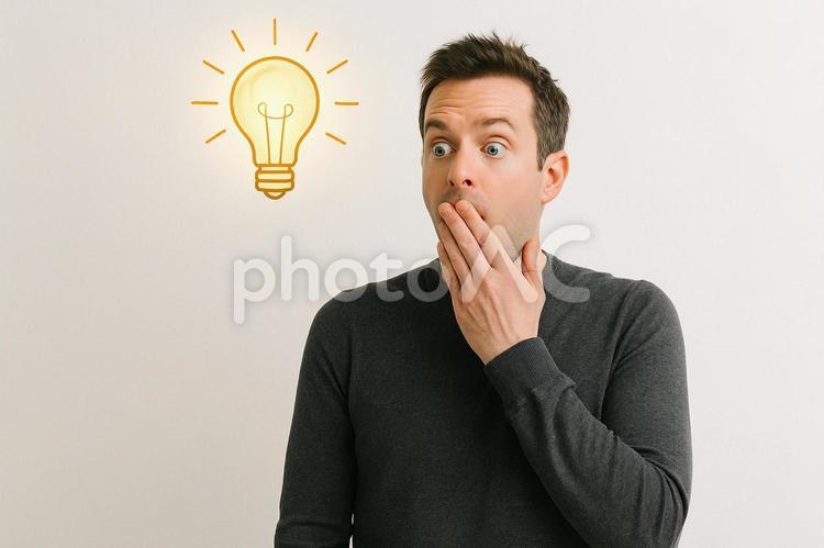 驚いた表情の男性と光の電球 驚き,男性,電球の写真素材