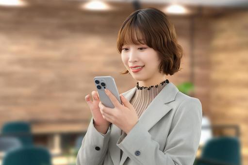 スマホを使う笑顔の女性・ビジネスウーマン 女性,スマホ,スマートフォンの写真素材