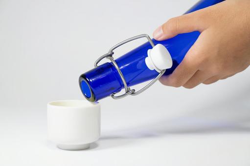 青い瓶から白いお猪口に注ぐクローズアップ 注ぐ,瓶,青の写真素材