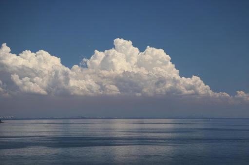青空ともくもく雲と青い海と対岸の街並み 青空ともくもく雲と青い海と対岸の街並みの写真