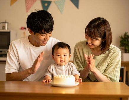 赤ちゃんの誕生日をお祝いする若い夫婦 赤ちゃんの誕生日をお祝いする若い夫婦の写真