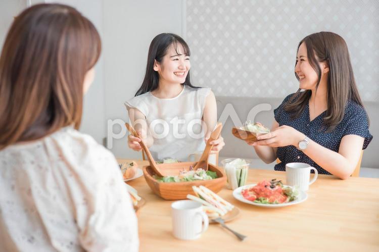 食事会で料理を取り分ける女性 女子会,カフェ,女性の写真素材