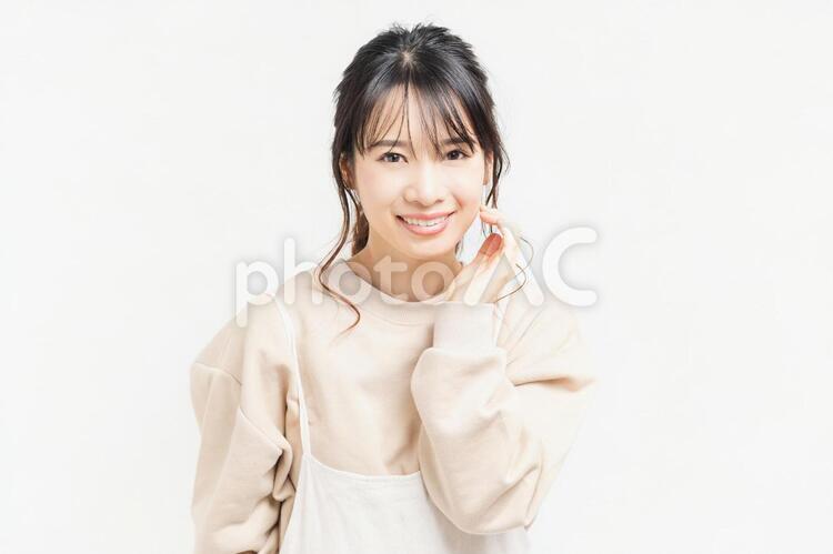 頬に手を当てる笑顔の若い女性 女性,頬,笑うの写真素材