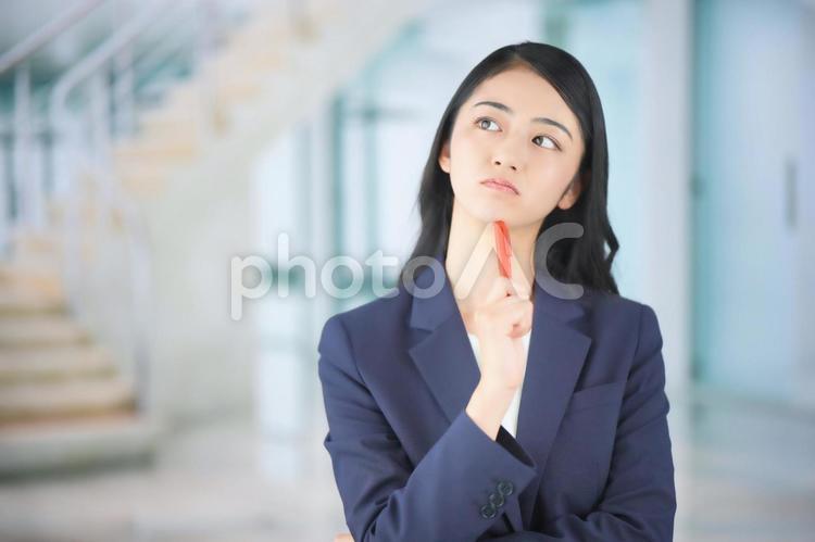 顎にペンを当てているビジネスウーマン 女性,ビジネスウーマン,会社員の写真素材