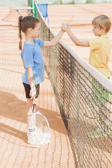 ネット越しにタッチを交わす子供たち 男女,子供,外国人の写真素材