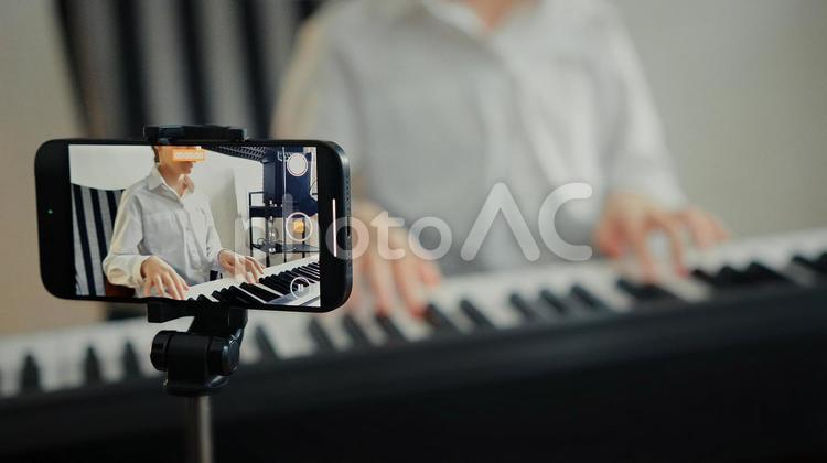 キーボードを練習する人の手元と携帯での撮影 キーボード,鍵盤,手元の写真素材