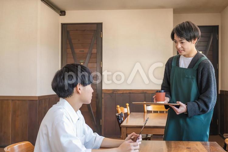 やり取りするスタッフと顧客 レストラン,カフェ,接客の写真素材