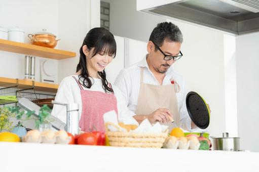 キッチンで料理を作るミドルの夫婦 料理,夫婦,家族の写真素材