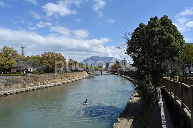 桜島と鹿児島市街地 鹿児島市,甲突川,川の写真素材