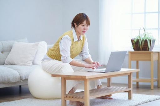 バランスボールに座りながらパソコンをする女性 女性,バランスボール,座るの写真素材