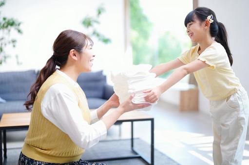 母に洗濯物を渡す女の子 母に洗濯物を渡す女の子 娘,タオル,洗濯物の写真素材