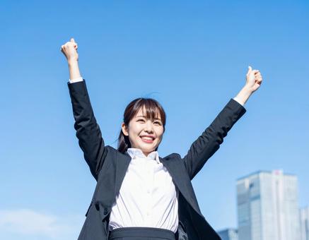 青空の下伸びをするビジネス女性・就活生 青空の下伸びをするビジネス女性・就活生の写真