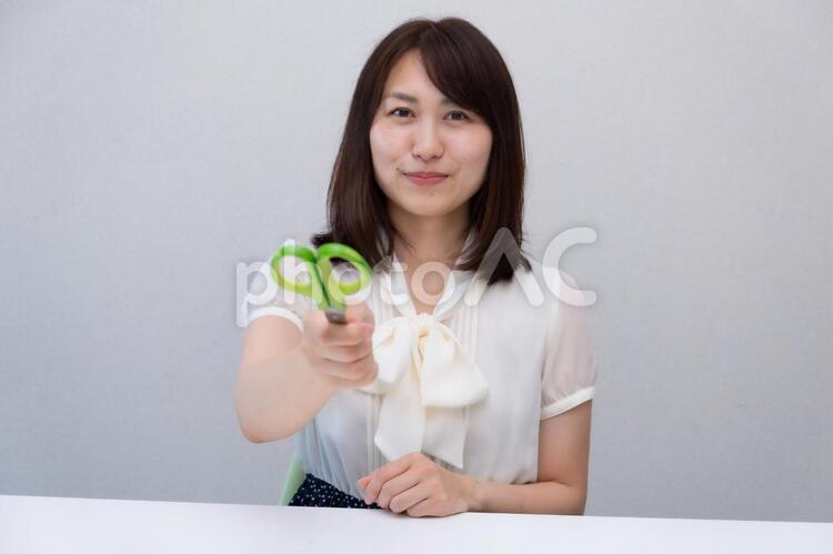 ハサミを渡そうとする女性 女性,ol,ハサミの写真素材