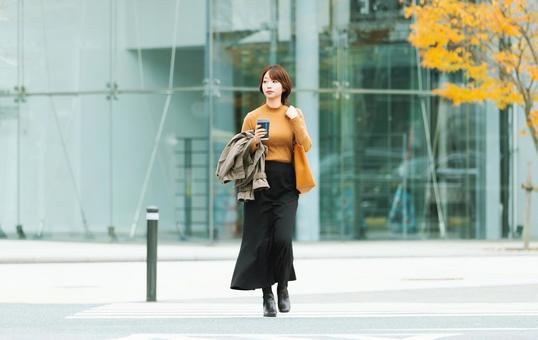 秋のオフィス街を歩く女性 秋のオフィス街を歩く女性 女性,秋,ビジネスの写真素材