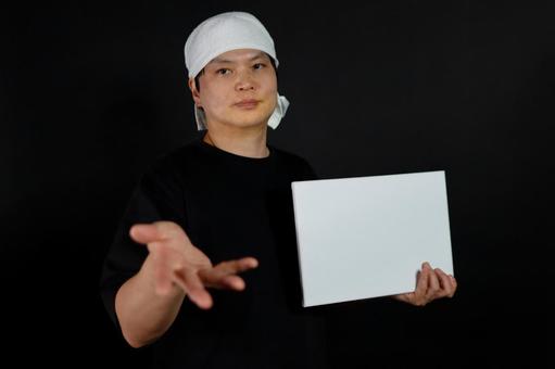 白い布を巻いた男性と白いボード 白い布を巻いた男性と白いボードの写真