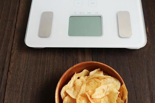 体重計とポテトチップス 体重計とポテトチップス 体重計,ポテトチップス,お菓子の写真素材