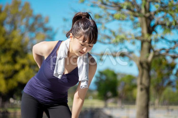 運動して腰を痛める女性 腰痛,腰,痛いの写真素材