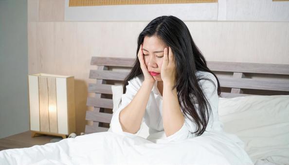 寝不足のパジャマを着た中年の日本人女性 寝不足のパジャマを着た中年の日本人女性の写真