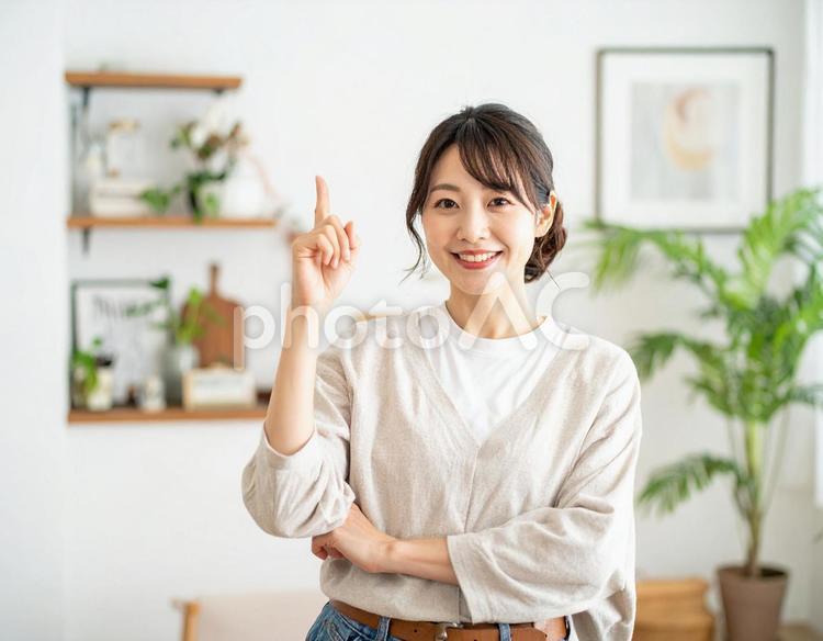 ひらめいた表情で指さす30代の日本人女性 主婦,日本人女性,30代女性の写真素材