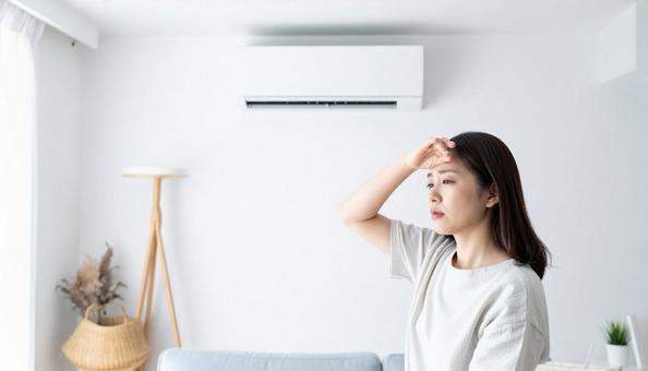 冷房が寒くて額に手をやる体調不良の女性 冷房が寒くて額に手をやる体調不良の女性の写真