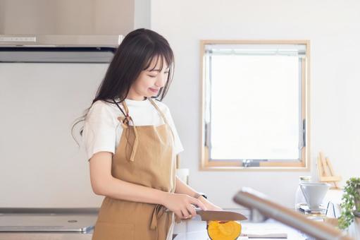キッチンで料理をする笑顔の女性 キッチンで料理をする笑顔の女性 女性,キッチン,料理の写真素材