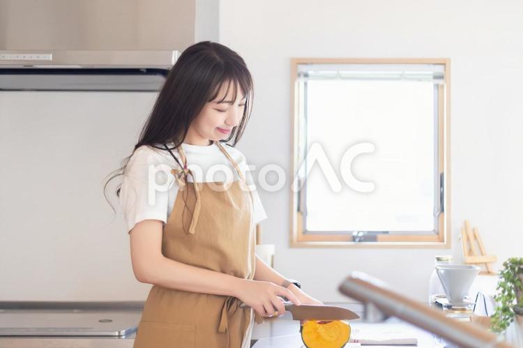 キッチンで料理をする笑顔の女性 女性,キッチン,料理の写真素材