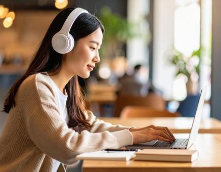 お気に入りの音楽を聴きながら勉強する女性 お気に入りの音楽を聴きながら勉強する女性の写真