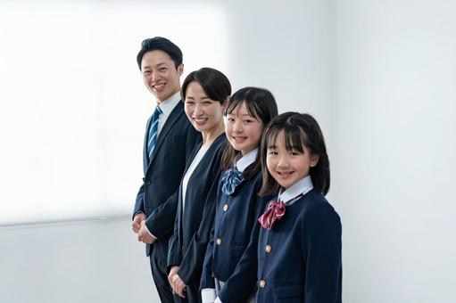 スーツを着た男女と制服を着た女の子二人 スーツを着た男女と制服を着た女の子二人 入学式,父母,母親の写真素材