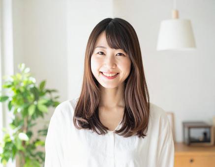 リビングで微笑む若い女性 リビングで微笑む若い女性の写真