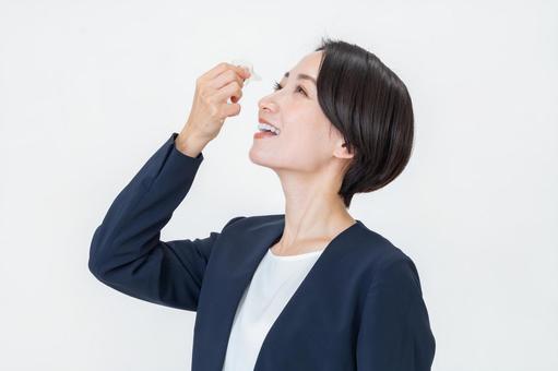 目薬を持つ女性 目薬を持つ女性 目薬,ビジネスウーマン,花粉症の写真素材