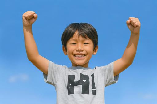笑顔と青空の元気いっぱいの男の子 笑顔と青空の元気いっぱいの男の子の写真