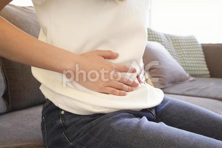 お腹を押さえる女性の腹痛イメージ 腹痛,お腹が痛い,生理痛の写真素材