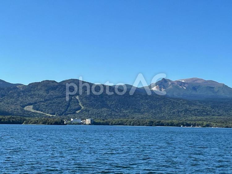 湖面の向こうに見える青空と山とホテル 山,湖,波の写真素材