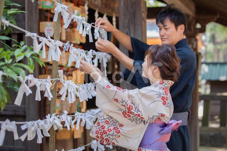 おみくじを結ぶ浴衣姿の男女 おみくじ,願い事,運勢の写真素材