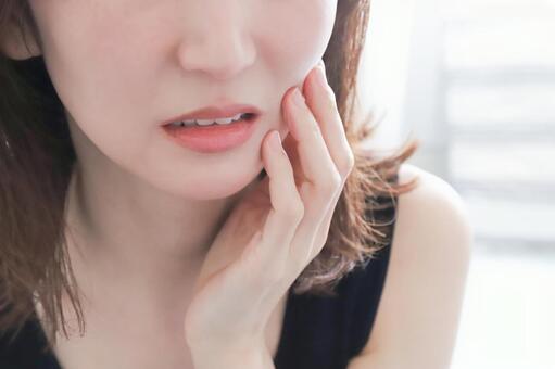 頬を押さえて歯の痛みに耐える女性 女性,歯痛,虫歯の写真素材