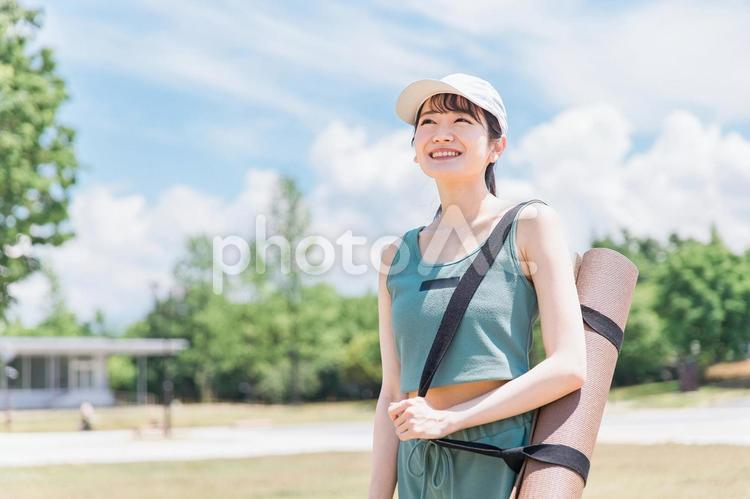 公園でヨガマットを持ったアジア人女性 ヨガ,女性,ダイエットの写真素材