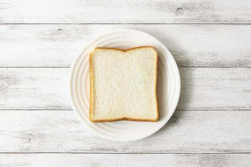 白皿に乗せた食パン1枚 白板 白皿に乗せた食パン1枚 白板の写真
