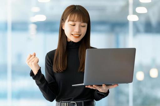 パソコンを見てガッツポーズをする女性 パソコンを見てガッツポーズをする女性 女性,ビジネス,笑顔の写真素材