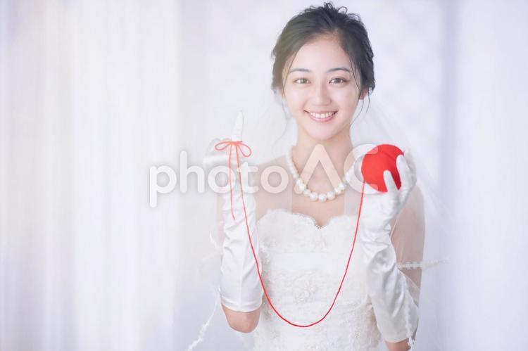 赤い糸を指に結んで記念撮影する花嫁 女性,花嫁,赤い糸の写真素材