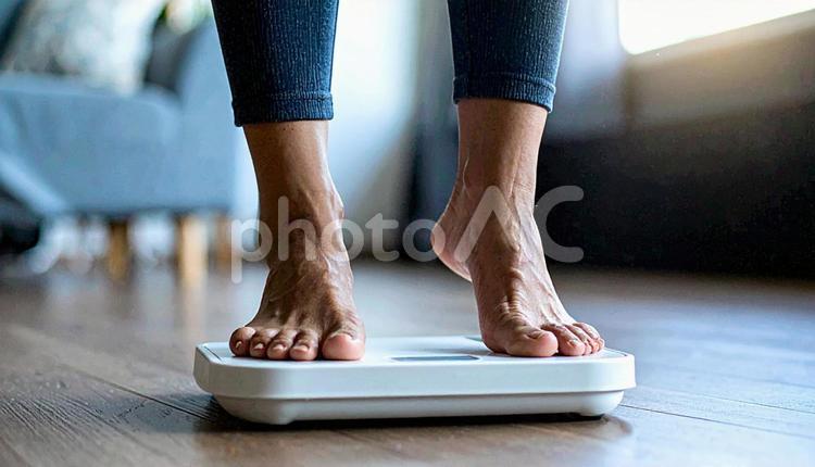 白い体重計に足を乗せる若い女性 体重測定,女性,ヘルスケアの写真素材
