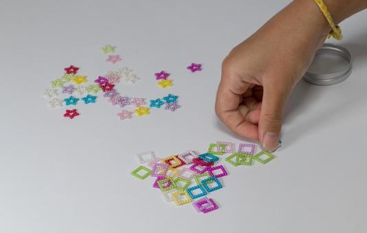 星と四角のビーズを拾い上げる手 星と四角のビーズを拾い上げる手 手,ビーズ,カラフルの写真素材